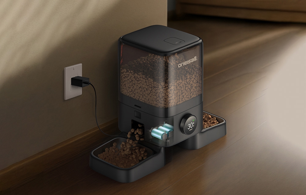 Black food dispenser with batteries connected to a power source.