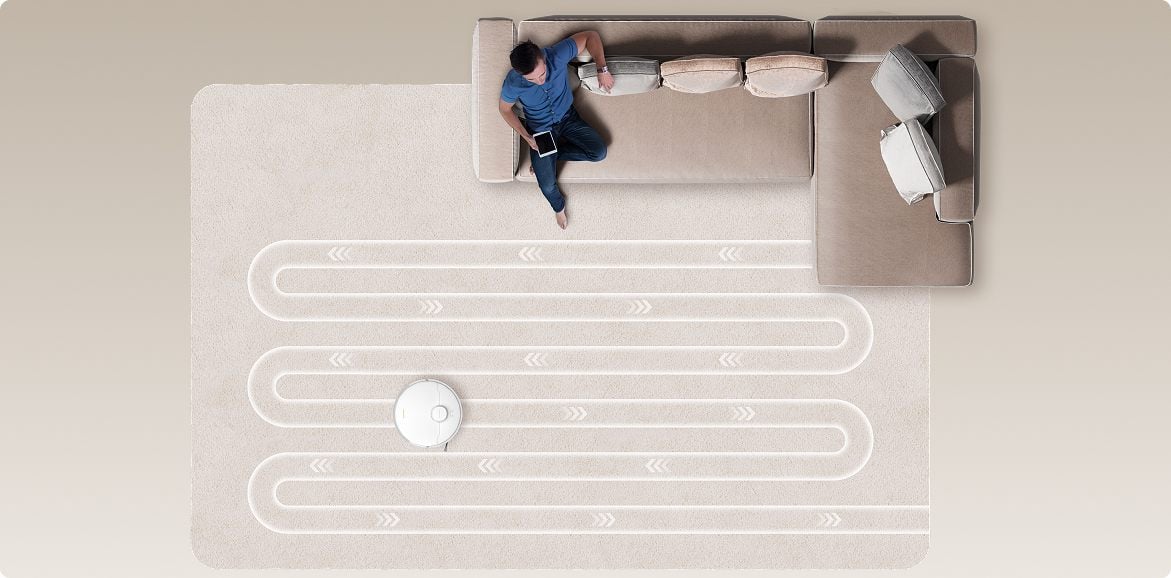 Mężczyzna kontroluje trasę sprzątania robota Dreame D20 Pro Plus z kanapy