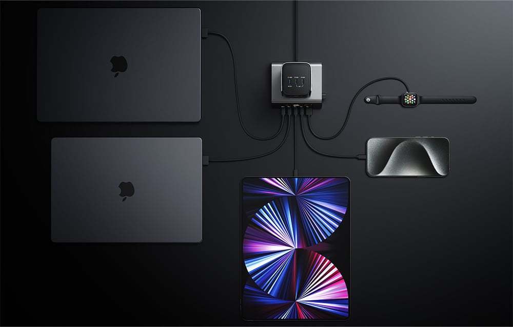 two laptops, a tablet, a smartphone, a power bank and a smartwatch charged via a docking station