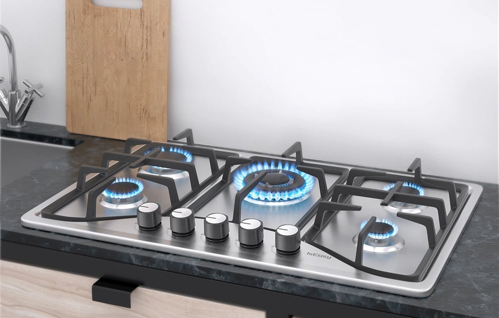 IsEasy gas hob with lit blue flames on a dark countertop with a wooden chopping board