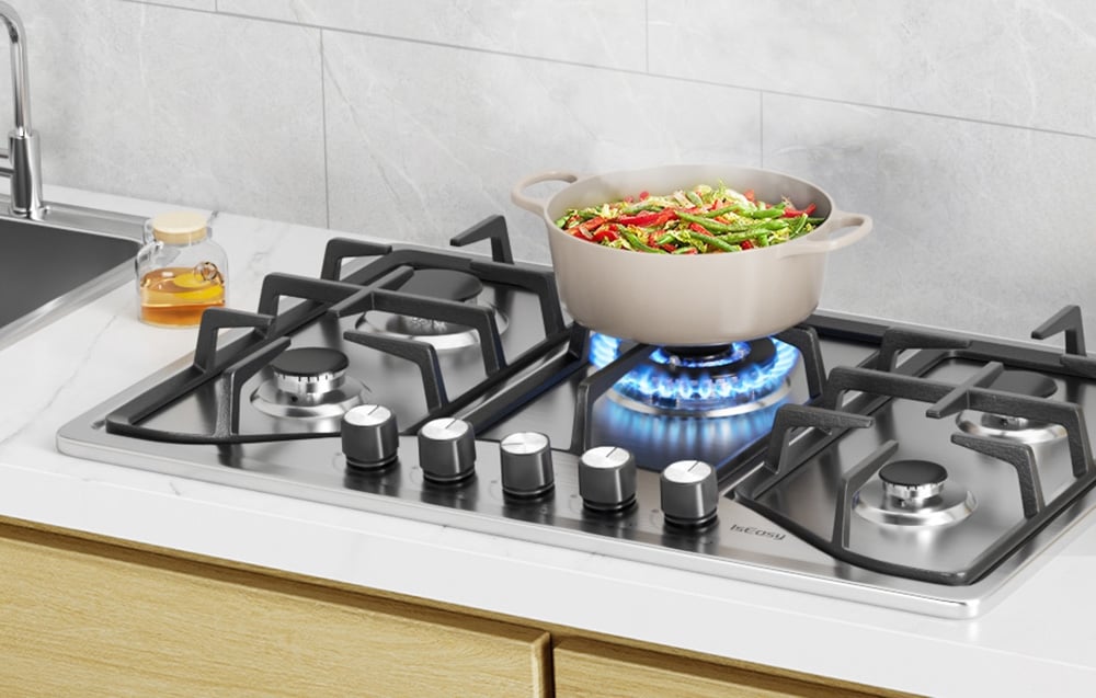 Gas hob with a beige pot of vegetables on a blue flame in a bright kitchen