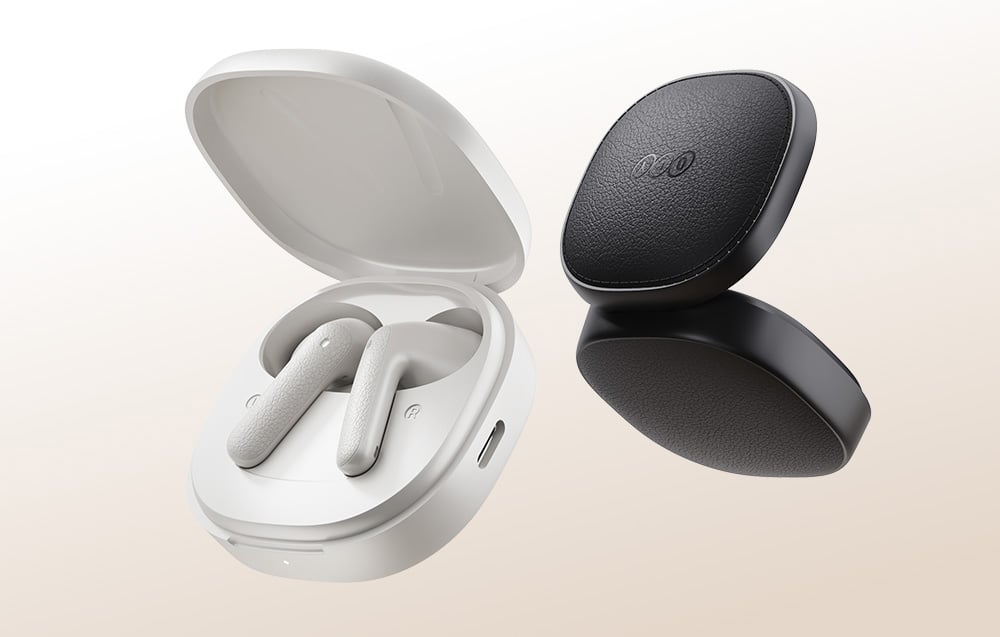 White and black cordless earphones over charging case on beige background.