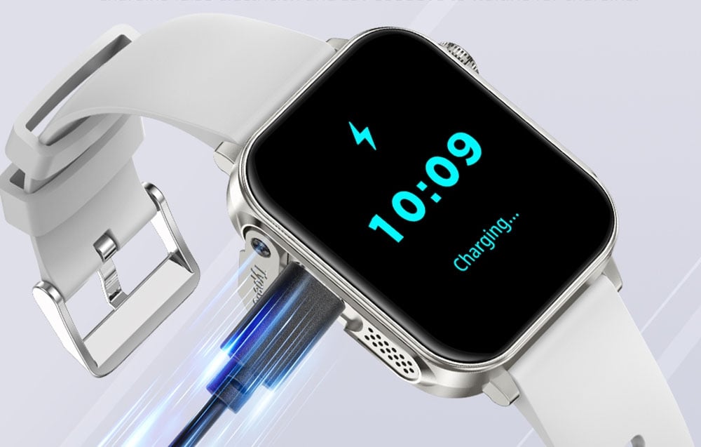 Ένα ασημί smartwatch με λευκό λουράκι συνδεδεμένο με καλώδιο USB-C.