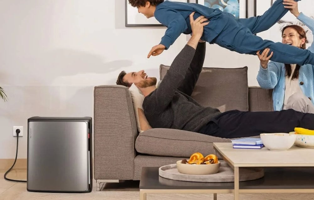 Family playing in living room, next to energy storage connected to wall outlet