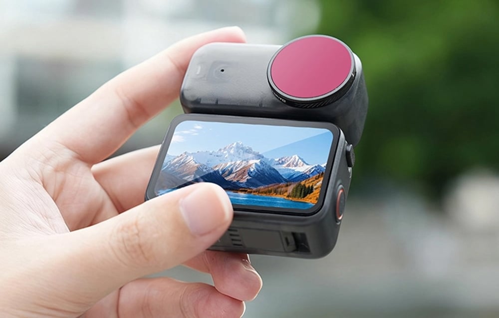 Hand-held camera with built-in screen and lens filter