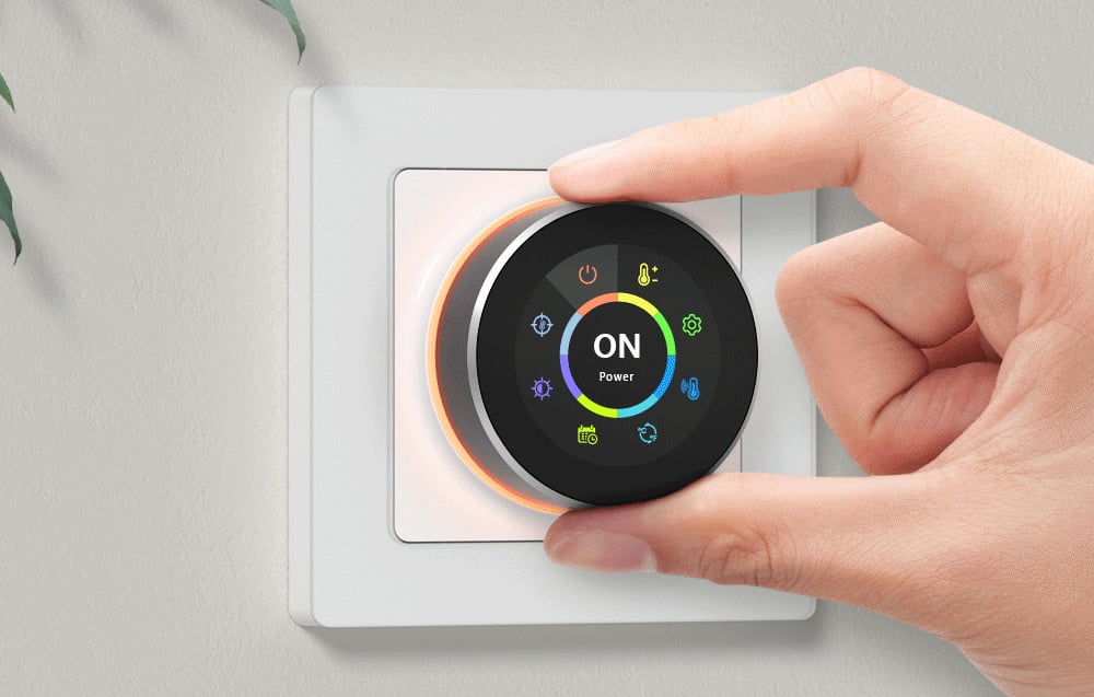 A hand setting the temperature on the thermostat.