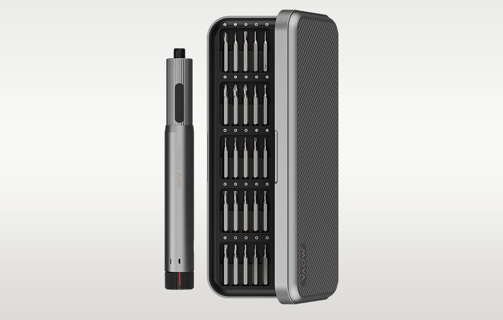 Wkrętak elektryczny obok półotwartego etui z bitami na szarym tle