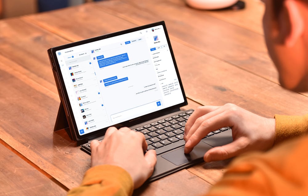 Ένας άνδρας εργάζεται σε ένα μικρό φορητό υπολογιστή στο γραφείο του
