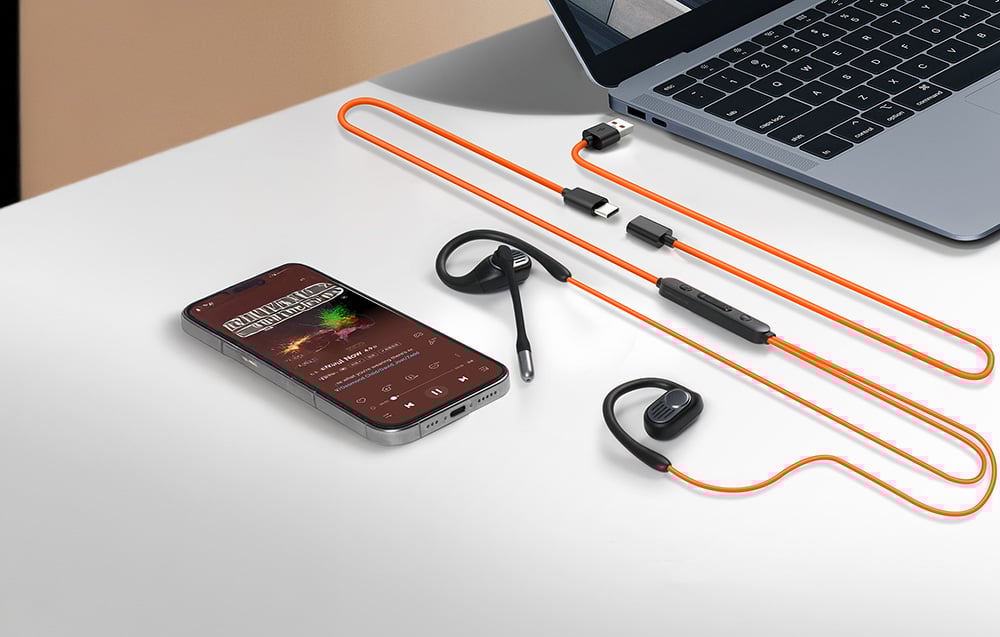 Smartfon, słuchawki przewodowe z mikrofonem i laptop na białym biurku