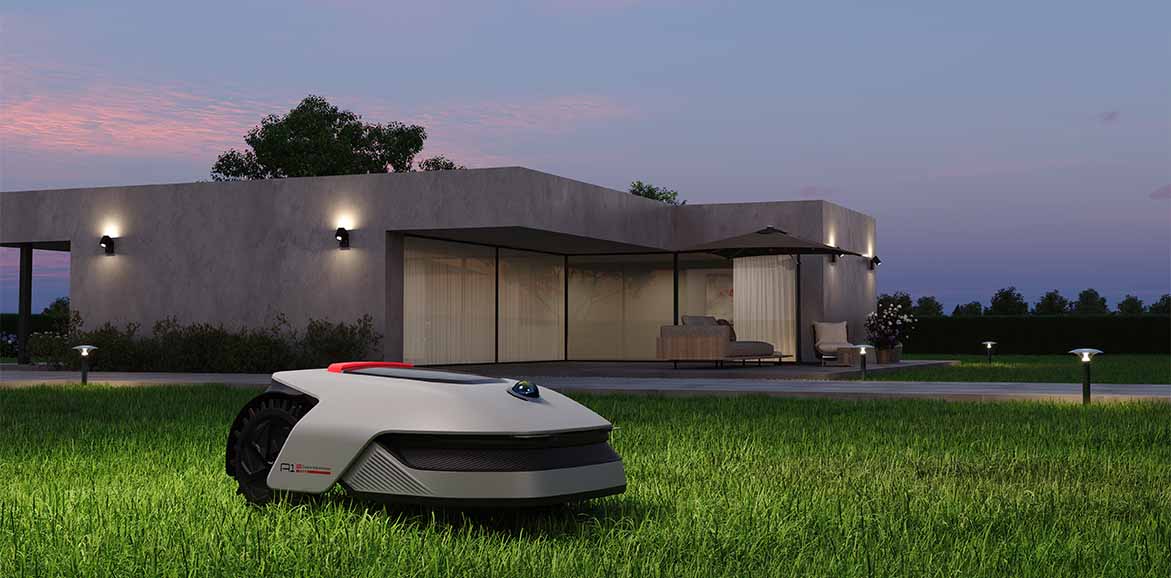 Robot koszący DREAME A1 Pro 1000 kosi trawnik o zmierzchu, a w tle widać elegancki, podświetlony dom.