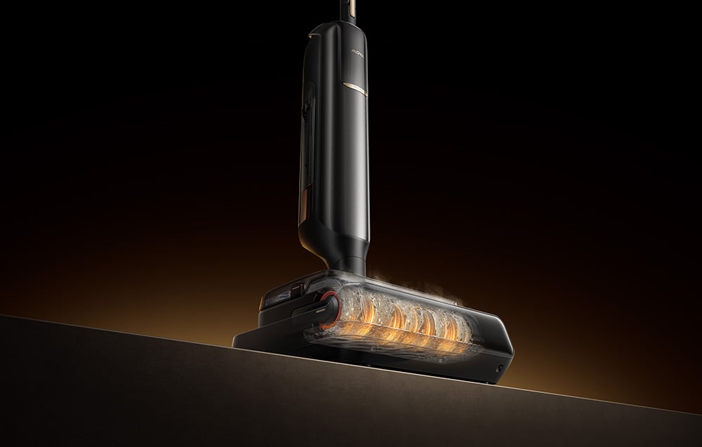 Čierna hlava umývacieho vysávača s osvetleným čistiacim valčekom je viditeľná z boku na tmavom pozadí.