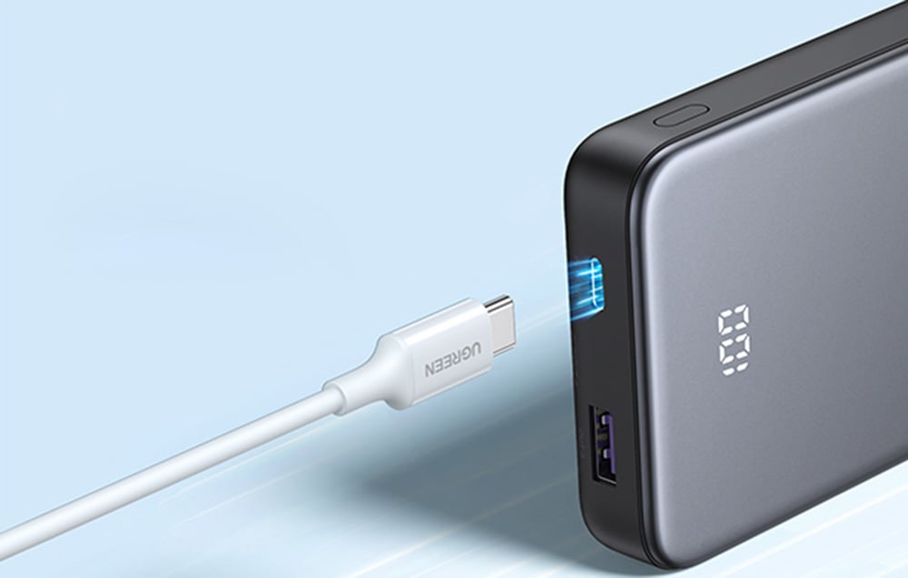 USB-C kábel, amely az Ugreen power bank megvilágított bemeneti portjához közelít.