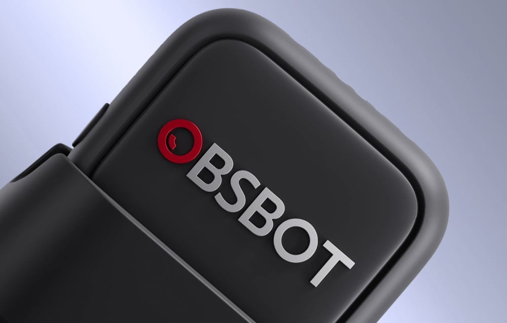 Close-up of the rounded corner of the OBSBOT microphone with a clearly visible red logo on the matte black housing