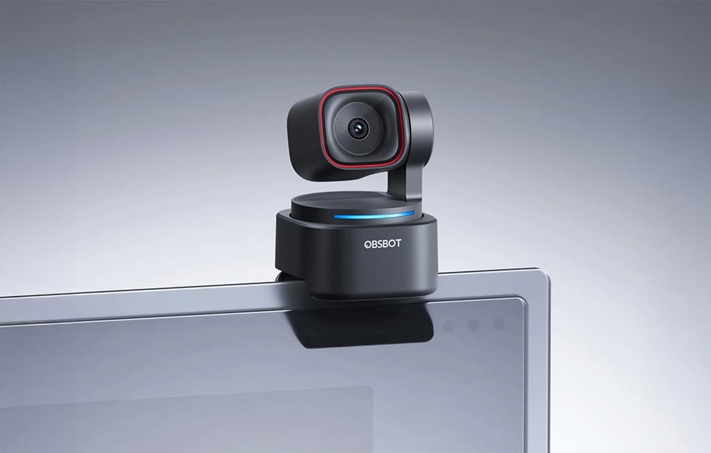 Kamera internetowa OBSBOT zamocowana na krawędzi monitora laptopa, pokazująca kompaktowy design z obrotową głowicą