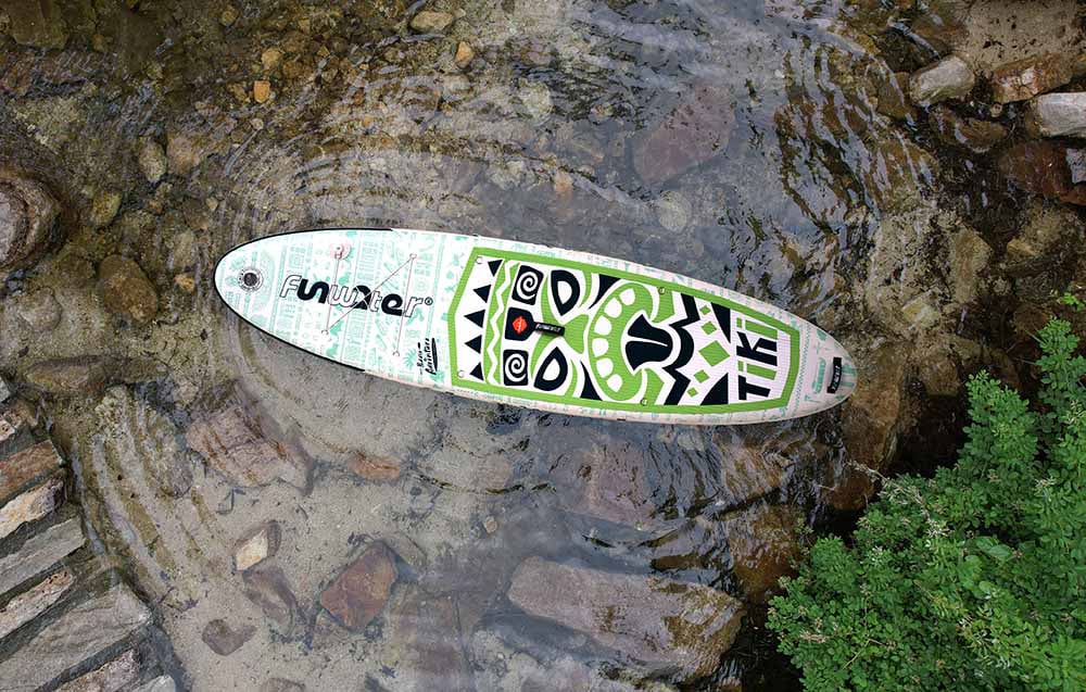 Colorful Funwater floating board lies on the water, surrounded by stones and plants
