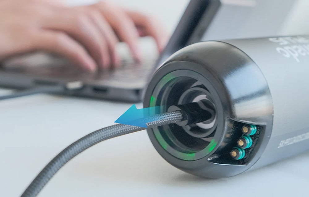 underwater scooter attached to a cable, next to a person using a laptop