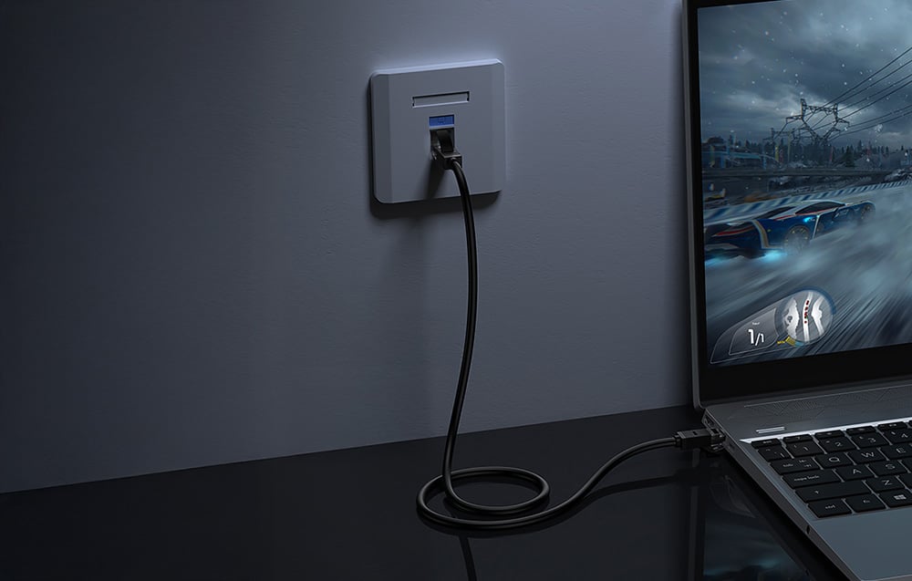 Kabel Ethernet podłączony do gniazda i laptopa z włączoną grą