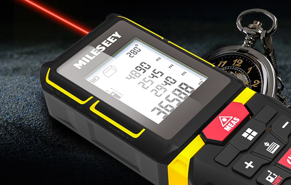Laser rangefinder emitting a red measurement beam, lying next to a classic pocket watch.
