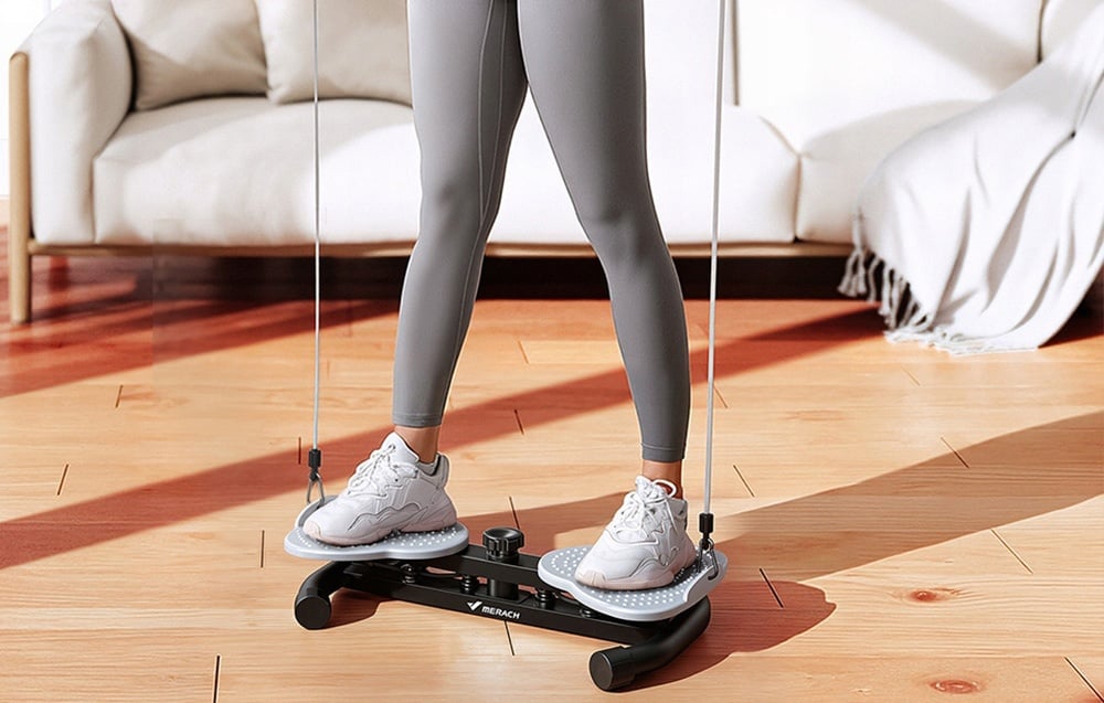 A woman in gray leggings stands on the MERACH twister, holding exercise bands in her hands