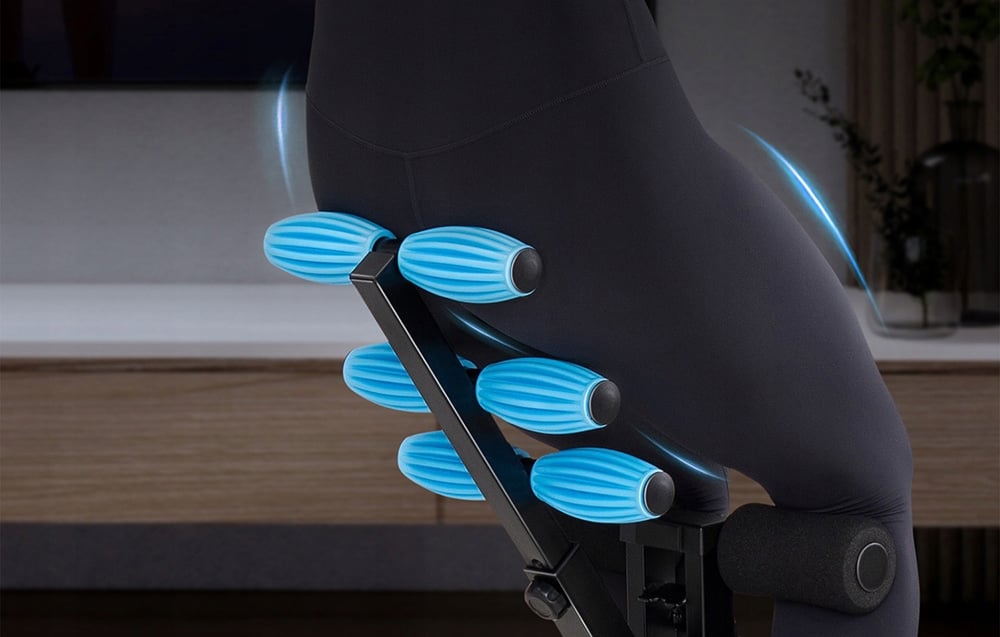 Close-up of a person sitting on a workout bench with six blue, elongated rollers