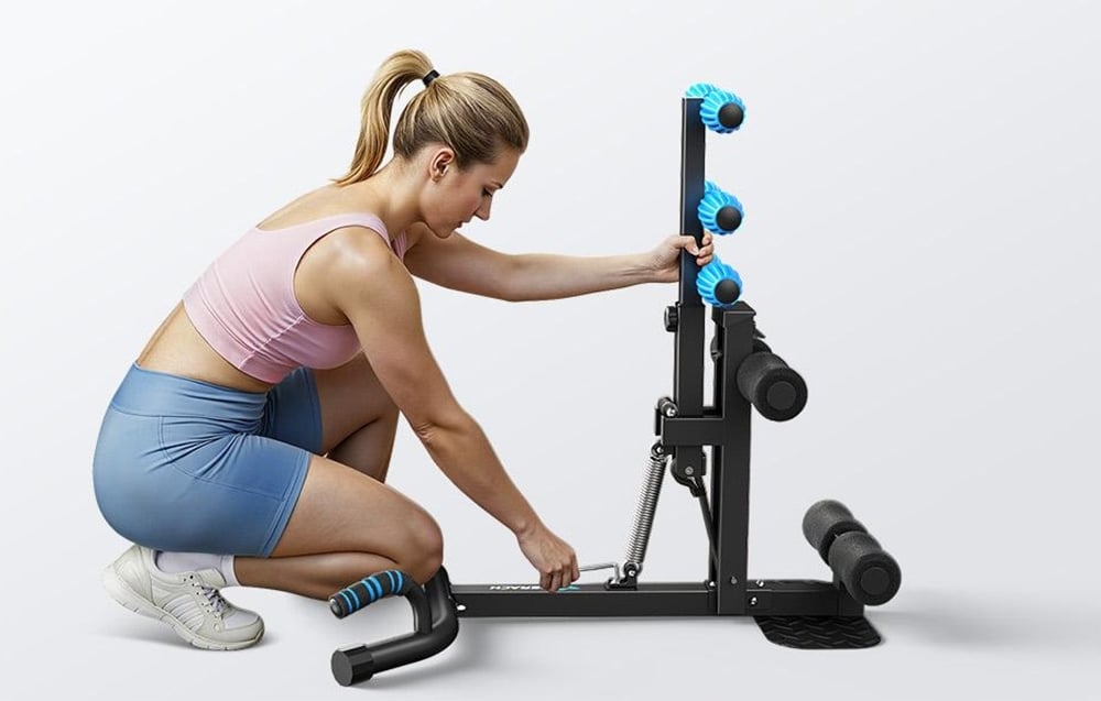 A woman squats and adjusts a black workout bench with a metal spring against a white background