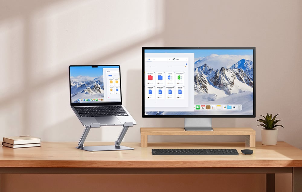 Egy munkaállomás egy fa íróasztalon, ahol egy laptop áll egy állítható állványon egy kiegészítő monitor mellett