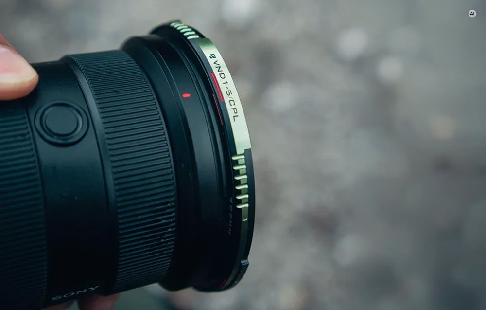 A close-up of a camera lens with a Freewell True Color VND CPL adjustable neutral density filter attached
