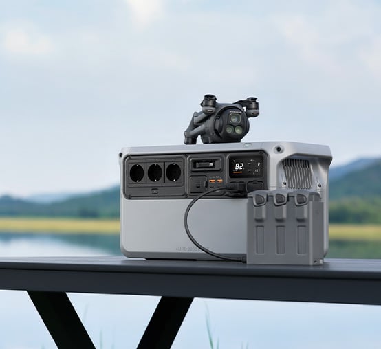 Stacja zasilania AURO 2000 ELITE na stole z dronem na górze i podłączonym modułem ładowania akumulatorów