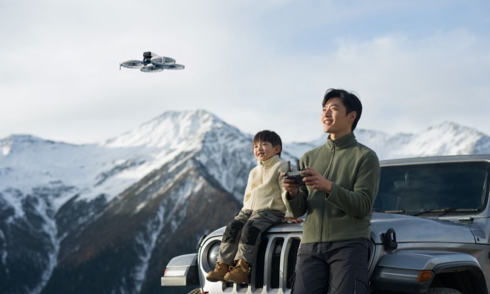 Ojciec z synem latają dronem w górach obok samochodu